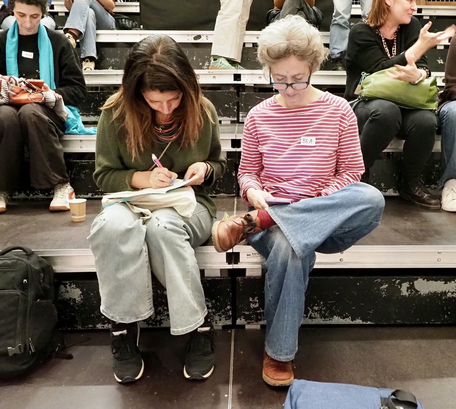 Two women writing in notebooks