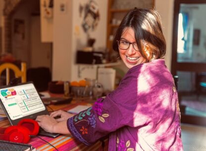 A woman working at her desk with the SessionLab planner on her computer screen