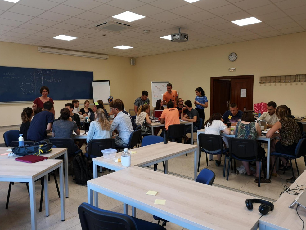 groups of university students working together at different tables