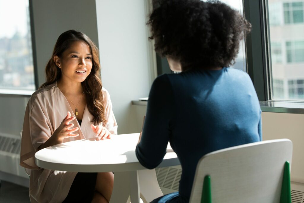 two professional women talking across a table