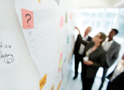 Two office colleagues planning a project at a whiteboard