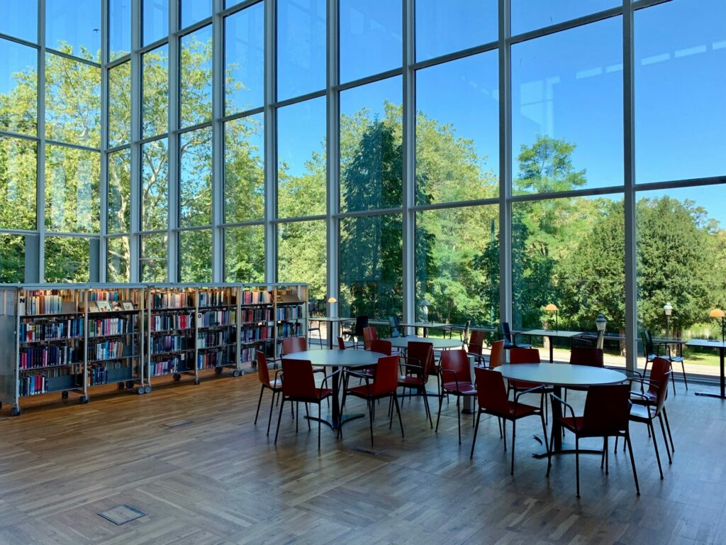 a bright space with a library and round tables