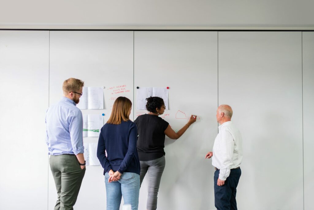 group of people working on a whiteboard